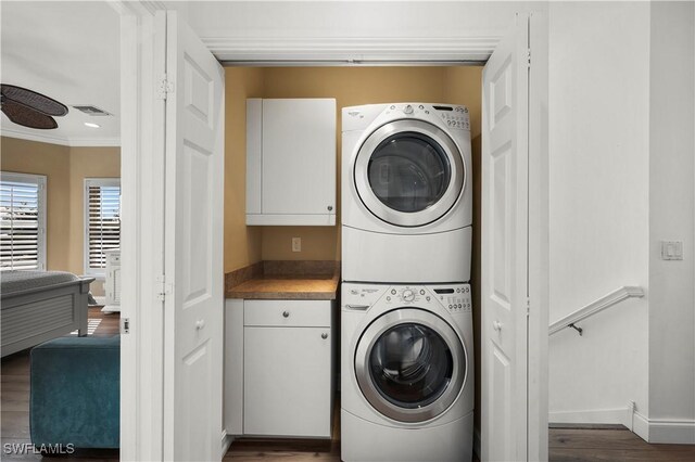 270 Delmar Ave, Fort Myers Beach, FL 33931 - laundry area with estacked washer and dryer, cabinet space, crown molding, baseboards, and dark wood-style floors