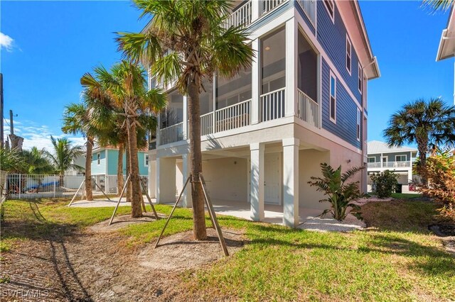 270 Delmar Ave, Fort Myers Beach, FL 33931 - rear view of house with a sunroom, stucco siding, and a patio