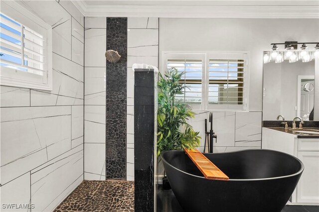 270 Delmar Ave, Fort Myers Beach, FL 33931 - bathroom featuring crown molding, a freestanding bath, vanity, tile walls, and healthy amount of natural light