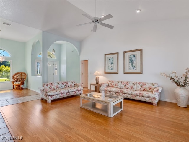 living room with light hardwood / wood-style flooring, high vaulted ceiling, and ceiling fan