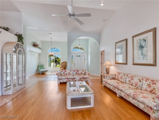 living room featuring ceiling fan, high vaulted ceiling, and light wood-type flooring