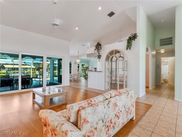 living room with light hardwood / wood-style flooring and high vaulted ceiling