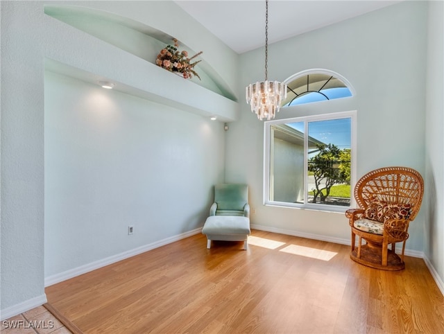 living area with an inviting chandelier and light wood-type flooring