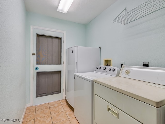 laundry room featuring washer and clothes dryer and light tile patterned floors