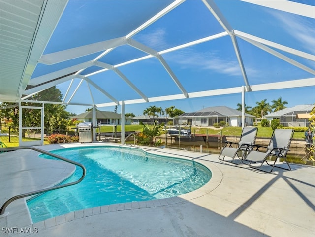 view of pool with a patio area, a lanai, and a water view