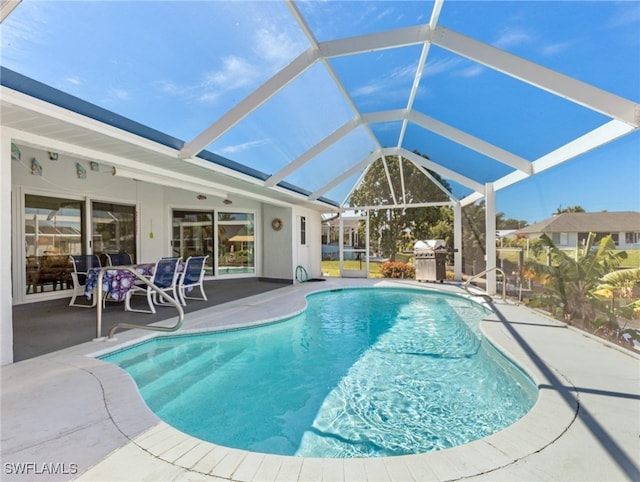 view of swimming pool with a patio area and a lanai