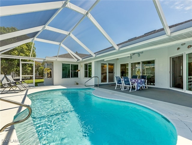 view of pool with a patio area and glass enclosure