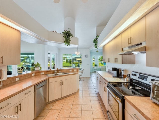 kitchen featuring sink, appliances with stainless steel finishes, decorative light fixtures, and light tile patterned floors