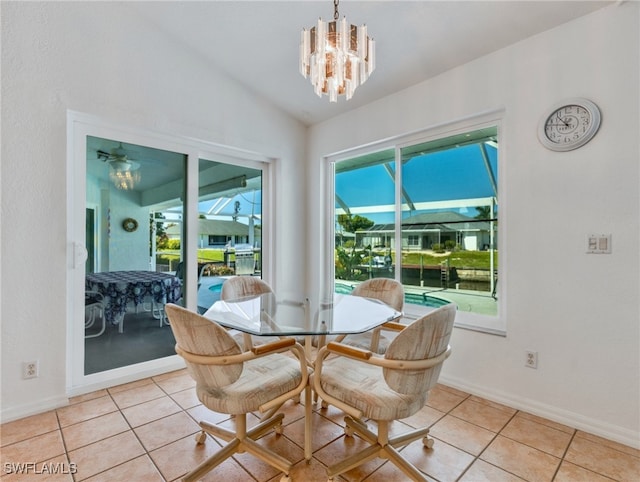 tiled dining room with a notable chandelier and lofted ceiling