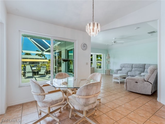 tiled dining area featuring lofted ceiling, ceiling fan with notable chandelier, and a healthy amount of sunlight