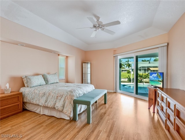 bedroom with light hardwood / wood-style flooring, a textured ceiling, access to exterior, and ceiling fan