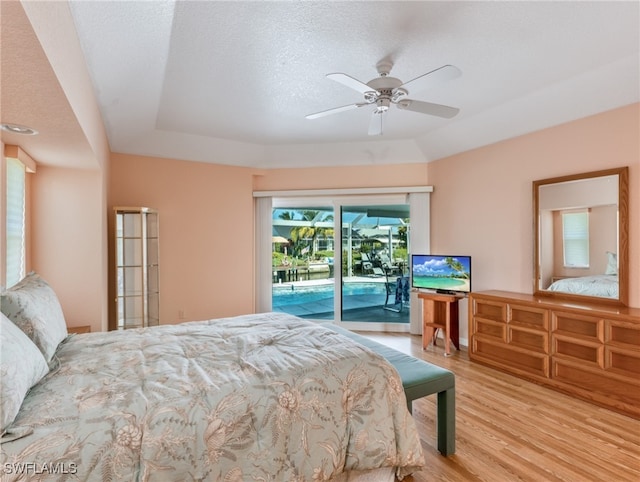 bedroom with light hardwood / wood-style flooring, access to outside, a textured ceiling, and ceiling fan