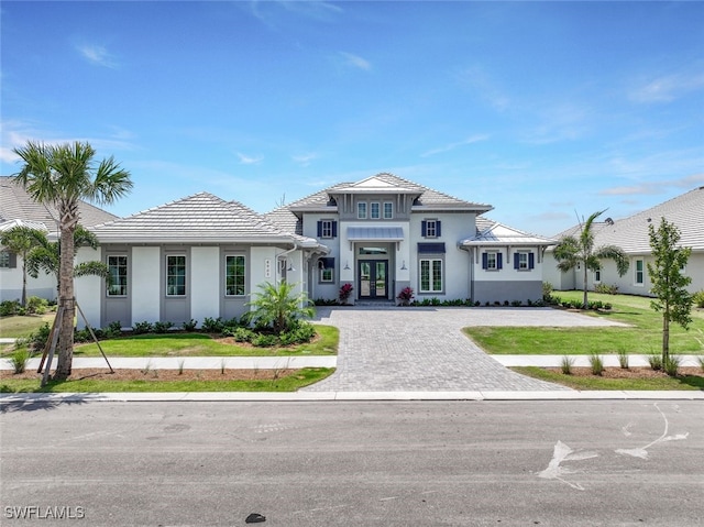 8903 Nevis Way, Naples, FL 34112 - prairie-style house featuring a tiled roof, decorative driveway, stucco siding, and french doors