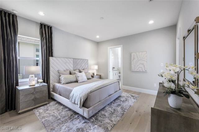 bedroom featuring ensuite bath and light hardwood / wood-style flooring