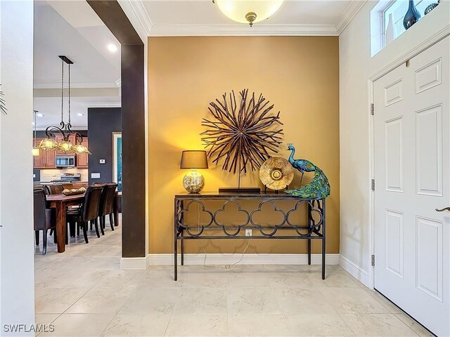 entryway featuring ornamental molding and a chandelier