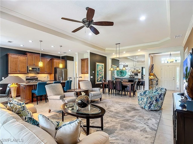 tiled living room with ceiling fan, ornamental molding, and a raised ceiling