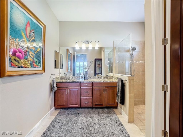 bathroom featuring a tile shower, vanity, and tile patterned flooring