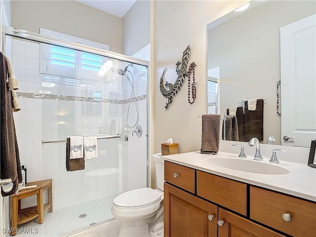 bathroom featuring vanity, an enclosed shower, and toilet