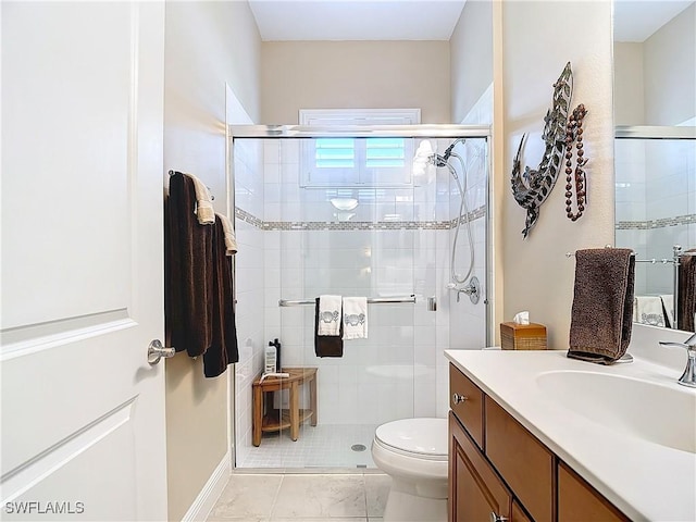 bathroom with toilet, vanity, and a shower with shower door