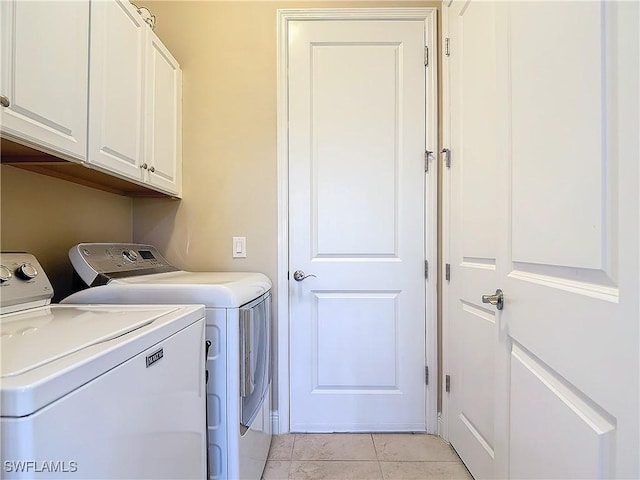 clothes washing area featuring cabinets, washing machine and clothes dryer, and light tile patterned flooring