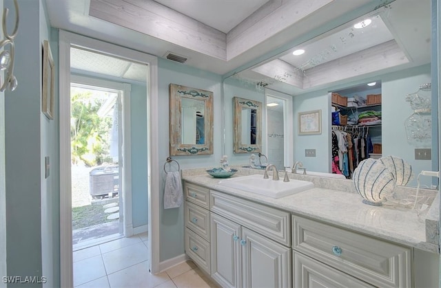 bathroom featuring vanity, a tray ceiling, and tile patterned floors