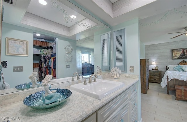 bathroom featuring tile patterned floors, a tray ceiling, ceiling fan, vanity, and wood walls