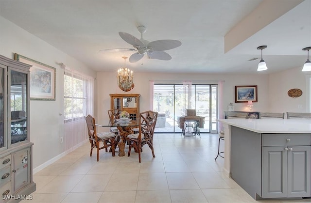 dining area featuring light tile patterned flooring, ceiling fan with notable chandelier, and a healthy amount of sunlight