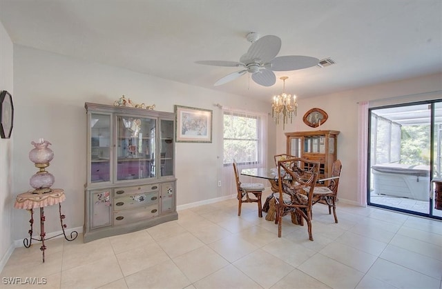 tiled dining area with a wealth of natural light and ceiling fan with notable chandelier