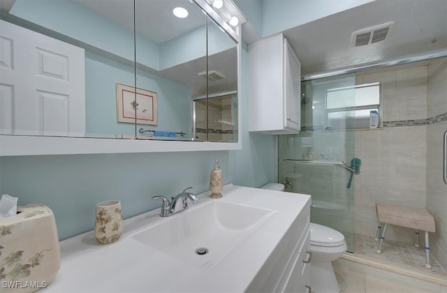 bathroom with vanity, tile patterned flooring, toilet, and walk in shower