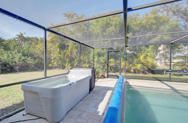 view of swimming pool featuring a hot tub, a patio area, and a lanai