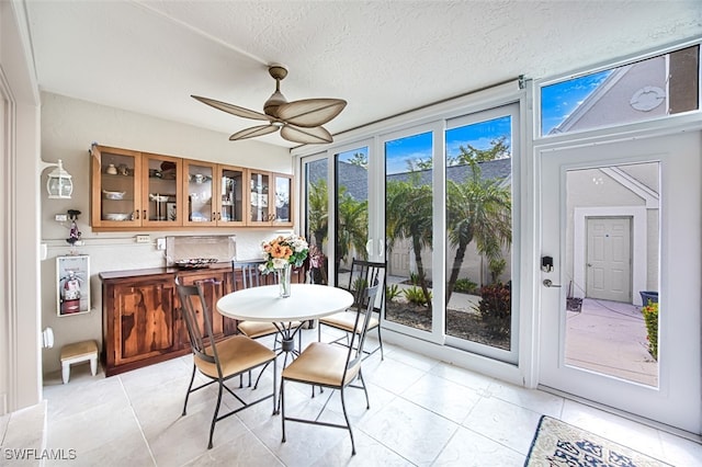 tiled dining room featuring a textured ceiling and ceiling fan