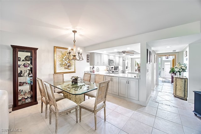 dining area featuring ceiling fan with notable chandelier