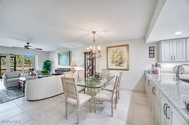 dining room featuring ceiling fan with notable chandelier and light tile patterned floors