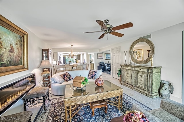 living room with ceiling fan with notable chandelier and light tile patterned floors