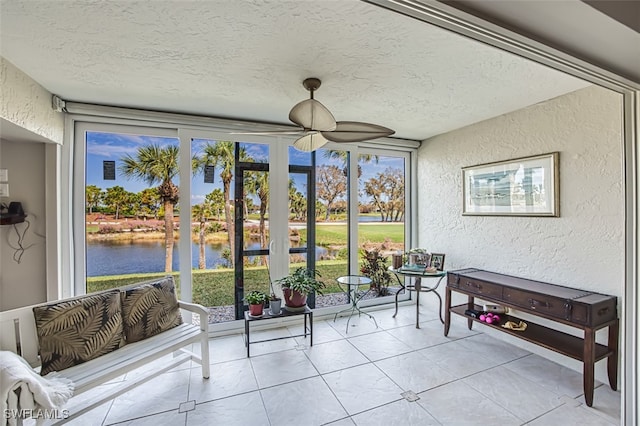 sunroom with a water view and ceiling fan