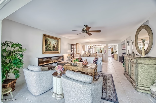 living room with light tile patterned flooring and ceiling fan with notable chandelier