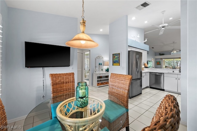 tiled dining space with vaulted ceiling and ceiling fan