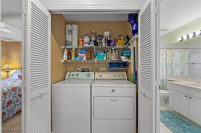 laundry room featuring light tile patterned floors and washer and clothes dryer