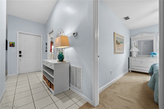 hallway with vaulted ceiling and light carpet