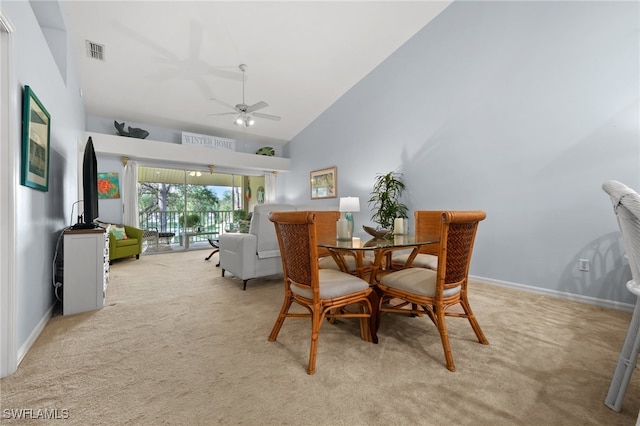 dining space featuring light carpet, high vaulted ceiling, and ceiling fan