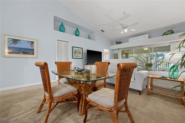 carpeted dining area with ceiling fan and high vaulted ceiling