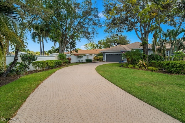 ranch-style house featuring a front yard and a garage