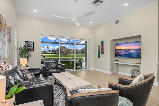 living room featuring light hardwood / wood-style flooring and ceiling fan