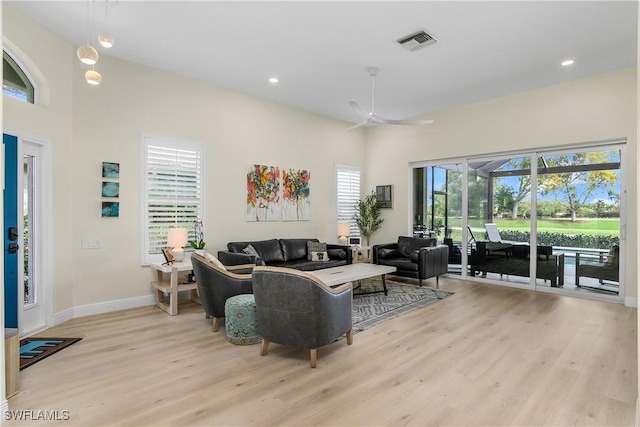 living room with ceiling fan and light hardwood / wood-style flooring