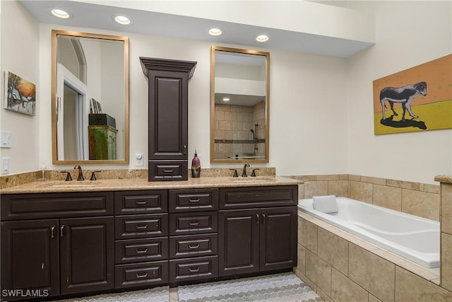 bathroom with vanity and tiled bath