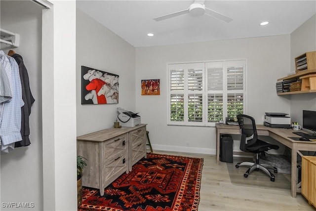 office with ceiling fan and light hardwood / wood-style flooring