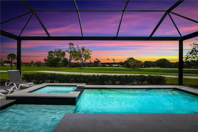 pool at dusk featuring an in ground hot tub, a lanai, and a patio