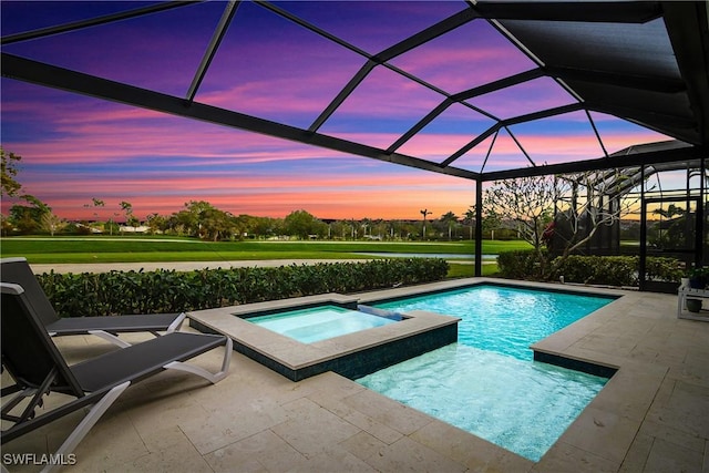 pool at dusk featuring an in ground hot tub, glass enclosure, and a patio area