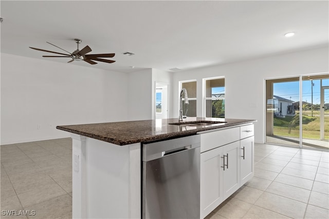 kitchen with a center island with sink, sink, light tile patterned floors, stainless steel dishwasher, and white cabinetry