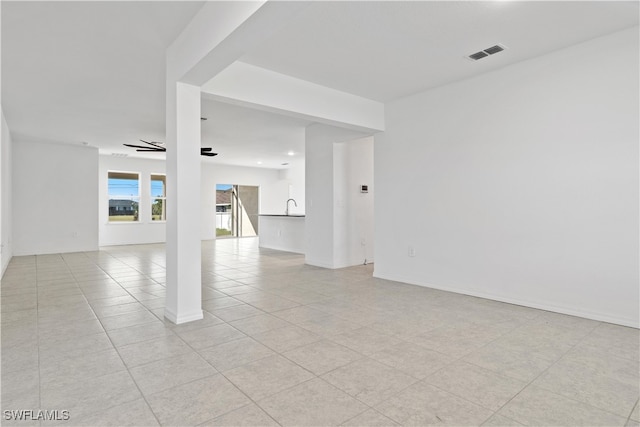 tiled empty room featuring sink and ceiling fan